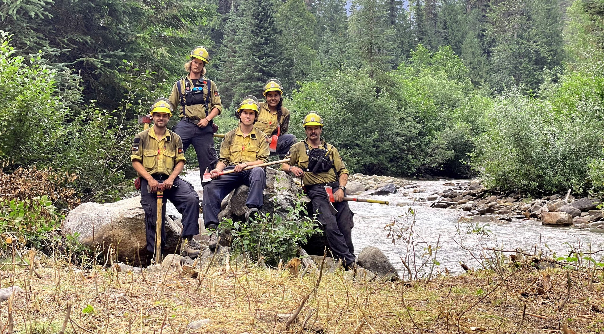 Strategic Natural Resource Group wildfire fighting crew sitting on a river bank